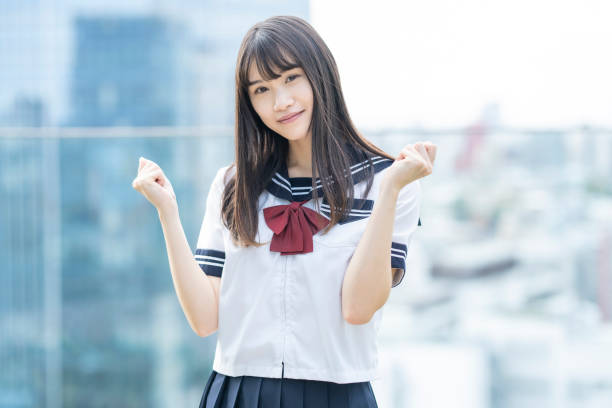 A female high school student posing supporting with a smile outdoors